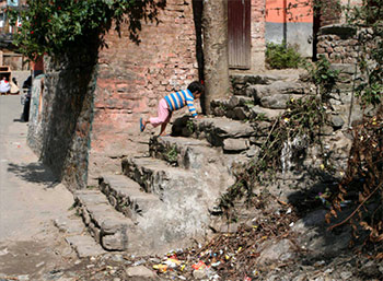Little girl playing above an open latrine